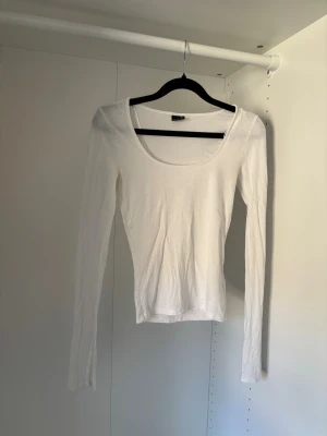 Vit Långärmad tröja från Gina  - Långärmad tröja med slits i ärmarna, använd få gånger så i fint skick. Har dock en liten liten typ ljusrosa fläck som syns på sista bilden.