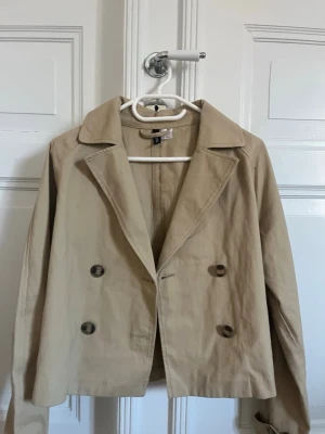  Trenchcoat  - Snygg beige trenchcoat ifrån HM. Storlek M men passar S bra med. Aldrig använd!