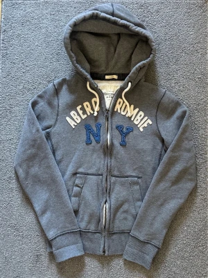 Vintage Abercrombie & Fitch Zip-Hoodie - Säljer denna riktigt snygga Abercrombie & Fitch koftan | Storlek S | Mycket bra skick | Längd≈67cm, Bredd armhåla-armhåla≈53cm | Model 175cm, 68kg | Hör av vid funderingar!