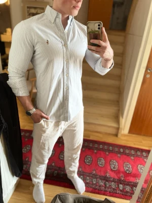 Blåvit randig skjorta från Ralph Lauren - Men fy vilken fräsch skjorta detta är inför en spektakulär sommar!🤩☀️Den är nästintill ny i skicket och denna är en riktigt hit enligt mig! Tveka inte vid frågor🙏🫶 