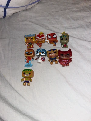 Funko pop Marvel superhjältefigurer samlarobjekt - Säljer ett set med små Marvel Funkopop figurer i plast. Figurerna föreställer bland annat Spiderman, Captain America, Iron Man, Thanos, Groot och Scarlet Witch. Flera av figurerna har färgglada detaljer och vissa har glittereffekter. Perfekt för samlare eller som dekoration. Sällsynta