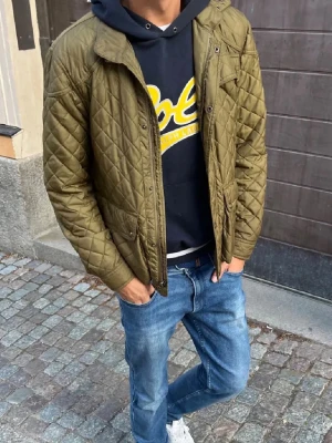 Polo Ralph Lauren Hoodie - Mörkblå hoodie med stor gul Polo-logga på bröstet och vita ränder på ärmslut och nederkant. Klassisk huva och mjukt material som känns skönt mot huden. Perfekt för dig som gillar streetstyle och vill ha något som sticker ut.