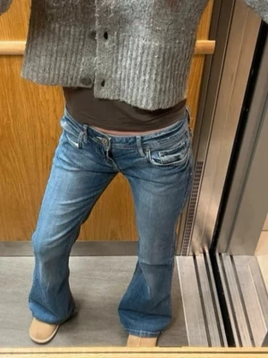 Blå bootcut jeans med låg midja - Super fina lowwaist jeans! Köpa i en vintage butik i London för ca 1100kr. Står ej någon storlek men jag är 174 på bilden och har vanligtvis storlek S. Skulle säga att de är som en S-M