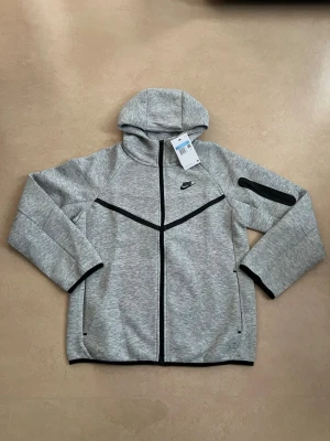 Nike tech fleece zip hoodie grå storlek medium - Nike Tech Fleece hoodie i nyskick. En av de mest populära Nike-plaggen just nu.  Oanvänd Perfekt året runt Väldigt hög efterfrågan  Skickas direkt 🚚 Bundle-rabatt finns.