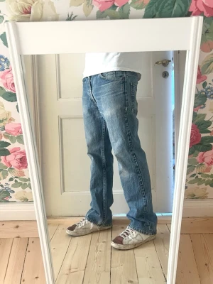 Slim bootcut Levi's 512 orange tab - Säljer ett par klassiska blå jeans från Levi's med slim bootcut passform och normal midja. Jeansen har fem fickor och en snygg tvättad look med lätt slitningar. Perfekta till sneakers och t-shirt för en avslappnad stil. Orange tab 512:or som är limited och riktigt ovanliga just nu.