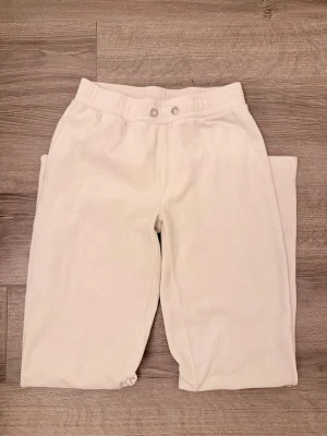 Mjuka mjukisbyxor XS/S - Säljer ett par mjuka och mysiga mjukisbyxor med stretchig resår i midjan  Byxorna är raka i modellen och har en mjuk, skön känsla. Inga fickor och inget band, men ett nytt kan dras igenom. Benlängd: 70cm. Figursittande vid Small och avslappnad vid XS (så var det för mig)