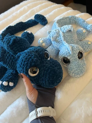 Två blåa virkade drakar  - Den enda draken är cirka 51 cm lång om man sträcker ut svansen❤️ Virkat med Garn från Rista, Klara🩵 Silvriga ögon som sitter som bergen🥰 Den andra är större cirka 65cm, virkat med garn från Hobbi, Baby Snuggle💙💙 