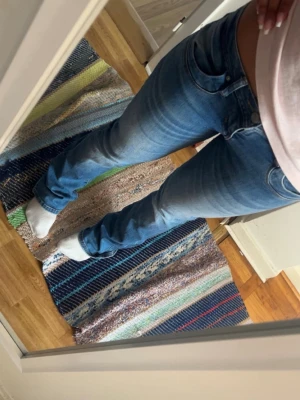 Bootcut jeans  - Säljer ett par snygga blå bootcut jeans från LTB med klassisk femficksmodell och slitningar för en cool look. Jeansen har  låg midja och är i storlek 27/34
