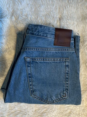 Blå raka jeans - Säljer ett par blåa raka jeans från NA-KD som tyvärr inte passar längre. Skulle säga att de är low/mid waist. Har klippt upp de så de passar min längd på 163 cm 🤗