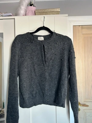 Mörkgrå kofta med pärlor  - Mysig mörkgrå stickad kofta från H&M med dekorativa pärlor på framsidan. Inga defekter eller likande, säljer då den inte kommer till användning och tar plats i garderob❤️