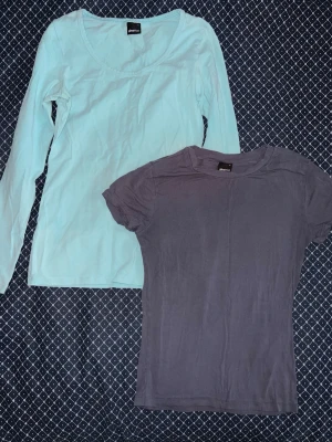 Två basic toppar från Gina Tricot - Säljer två basic toppar från Gina Tricot. En ljusblå långärmad topp med rund halsringning och en mörkgrå kortärmad topp från Gina tricots soft touch kollektionen. Båda är i mjuk bomull och perfekta att matcha till olika outfits. Både är i storlek s. 
