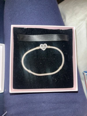 Två armband från Pandora - Säljer snyggt armband från Pandora. I silverfärg med ett oändlighetstecken som lås. Har klassisk ormkedjedesign och levereras i original ask. Perfekt för dig som gillar stilrena och trendiga smycken. Står på baksidan ”Family forever and Always” men syns knappt när man använder de. Säljer då jag vill köpa ett nytt samt att det har lite svårt att låsas men är inte ett större problem.       Pris kan diskuteras samt skriv vid frågor❤️❤️❤️