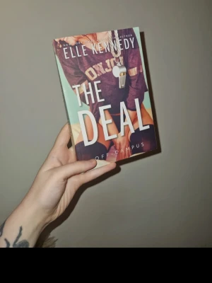 The Deal av Elle Kennedy - Säljer boken 'The Deal' av Elle Kennedy, en populär romantisk roman i Off Campus-serien. Perfekt för dig som gillar contemporary romance och college-miljöer. Katt finns i hemmet