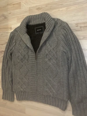 Fodrad stickad cardigan - Otroligt snygg grå fodrad sticksd cardigan med mönster. Passar perfekt till kallare väder. Priset kan såklart dikauteras
