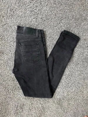 Svarta  tiger of sweden jeans  - Säljer ett par svarta jeans och klassisk femficksdesign. Jeansen har smal passform och är tillverkade i stretchigt denimtyg för extra komfort. Perfekta till en avslappnad streetstyle-look.
