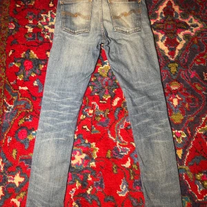 Nudie jeans - Säljer ett par sjukt feta Nudie jeans i storlek 26/32 och modell Lean Dean! Mått: Midja - 35 cm, innersöm - 71,5 cm, yttersöm - 101 cm. (Notera att måtten är ungefärliga och inte exakta) 