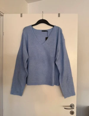 Stickad tröja  - Storlek XL. Aldrig använd. Finns en fläck på ena ärmen. 