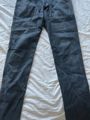 Mörkblå raka replay jeans - Säljer ett par mörkblå jeans med rak passform och klassisk femficksdesign. Jeansen har normal midja och är tillverkade i ett mjukt denimtyg som passar perfekt till en avslappnad stil. Inga synliga loggor eller detaljerade märken.