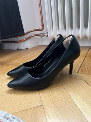 Svarta klassiska pumps med smal klack - Säljer ett par svarta pumps med spetsig tå och smal klack. Det sitter inklistrade glappskydd på insidan som syns på bilderna, går såklart att ta bort om det önskas. Aldrig använda utomhus men finns vissa täcken på användning om man letar lite. Skriv gärna om det finns några frågor!💗