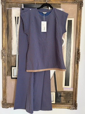 Blått och brunt mönstrat set från Atelier Capri  - Säljer ett snyggt sport set från Atelier Capri med topp och byxa i blått och brunt geometriskt mönster.Gå in på ateliercapri.com och titta på settet vidare och original pris. Aldrig använt. Byxan heter : pantalon färgen heter Blu milk choc strl S. Top i samma färg och storlek.