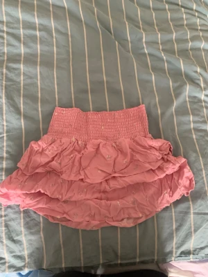 Rosa kjol - En rosa kjol med blommiga detaljer. Aldrig använd.