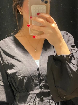 Svart blus med volang och knappar - Ny