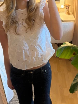 Vit blus med broderade detaljer - Söt vit blus med broderade mönster och volangdetaljer på axlarna. 💕