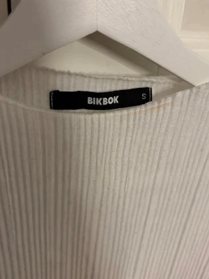 Vit ribbad långärmad tröja BikBok - Säljer en vit ribbad långärmad tröja från BikBok. Tröjan har rund halsringning och sitter snyggt på kroppen. Perfekt basplagg till garderoben och enkel att styla.
