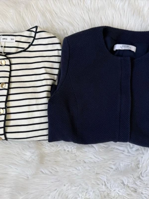 Randig kofta & mörkblå tröja Mango - Två snygga tröjor från Mango: en vit kofta med marinblå ränder och guldknappar samt en mörkblå, strukturerad tröja med rund hals.