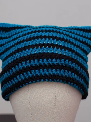 Crochet cat beanie virkad kattmössa blå turkos svart randig  - Helt ny virkad mössa med kattöron. Onesize, passar upp till ca 59cm. Virkad i mjukt akrylgarn. Den blå/turkosa färgen är svår att fånga på bild, den är lite starkare och lite mer turkos än på bilderna. Färger kan variera beroende på skärminställningar.