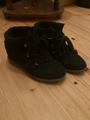 Svarta Isabel marants - Säljer ett par svarta Isabel Marant sneakers med klack i mkt gott skick. Köpta second hand men aldrig använt eftersom de är för små. Låda och dustbag medföljer🥰