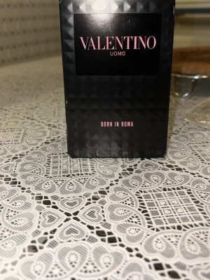 Valentino Uomo Born In Roma parfym 100ml - Valentino Uomo Born In Roma är en exklusiv herrparfym i en elegant svart kartong med subtila mönster och rosa text. Doften kommer i en 100 ml förpackning och utstrålar lyx och modern stil. Perfekt för dig som vill ha en unik signaturdoft.