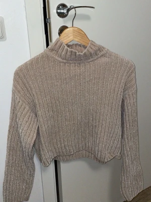 Den mysiga: ”Supermjuk ribbstickad dröm i beige - Säljer denna mjuka och sköna tröja i en fin beige/mullvadsfärgad nyans. Den har en ribbad textur och en trendig croppad passform som passar perfekt till högmidjade jeans eller kjolar.🤎🥥🍂