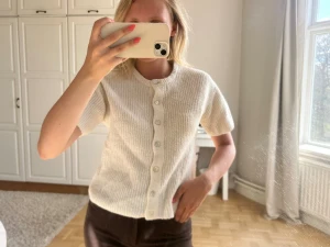 Vit ribbad kortärmad kofta💖💖 - Säljer en söt vit ribbad kofta med korta ärmar och rund hals. Koftan har knappar hela vägen framtill och är i ett mjukt, stickat material som känns riktigt skönt mot huden. Perfekt till jeans eller kjol för en clean look.