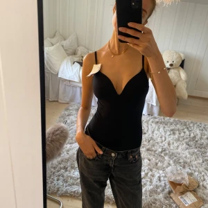 Svart body från H&M l - Denna jättepopulära slutsålda svarta figurnära body från H&M med tunna justerbara axelband.💘 Så mjuk och bekväm! Den har vaddering. Använt 1 gång❣️lappen är inte kvar🥰