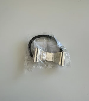 Hårsnodd med silverfärgad rosett - Cool hårsnodd med en metallic silverfärgad rosett i metall och svart elastiskt band. Perfekt för att ge din frisyr en snygg och trendig touch. Rosetten har en stilren och modern design som sticker ut.