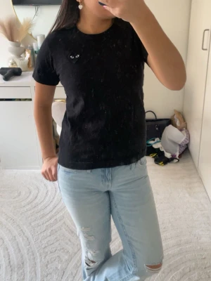 Ljusblåa bootcut jeans - Säljer ett par ljusblåa bootcut jeans med slitningar på benen. Jeansen har klassisk femficksdesign och är tillverkade i denim. De har en avslappnad passform och är perfekta för dig som gillar en trendig och bekväm stil.