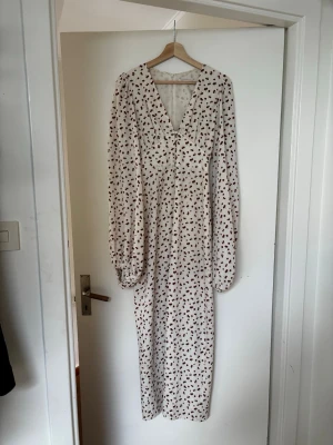 Adooreklänning körsbär - Långklänning från adoore, körsbärstryck. Den är använd ett fåtal gånger och det finns inga tecken på fläckar eller skavanker. Storlek 34