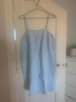 Blåvit randig sommarklänning - Säljer en tunn, luftig, super skön klänning med blåvita ränder. Klänningen är från Vero Moda i storlek S och använd endast ett fåtal gånger.