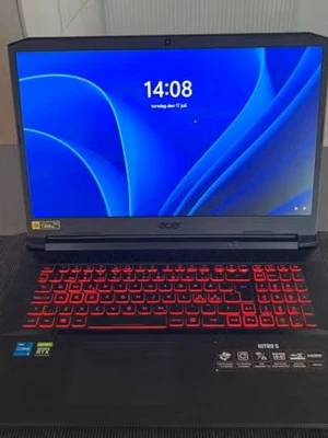 Acer Nitro 5 gaming laptop - Säljer en svart Acer Nitro 5 bärbar dator med röd bakgrundsbelyst tangentbord. Skärmen är stor och har tunna kanter. Datorn har Intel Core och NVIDIA RTX klistermärken, vilket visar att den är kraftfull och passar för gaming och tunga program.