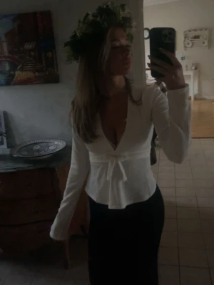 Vit omlottopp med knyt och v-ringning - Säljer en vit omlottopp med djup v-ringning och knyt i midjan. (Egna bilder) Inga defekter. Skriv till mig vid frågor💕💕