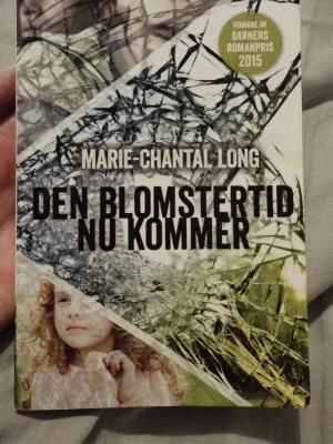 Den blomstertid nu kommer pocket - Spännande pocketbok av Marie-Chantal Long med titeln 'Den blomstertid nu kommer'. Omslaget har krossat glas och naturmotiv i grönt, vitt och svart. Boken vann Barnens Romanpris 2015 och är perfekt för dig som gillar nervkittlande berättelser.
