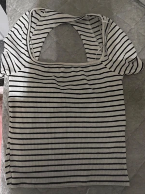 Randig topp med öppen rygg - Säljer denna söta toppen. Randig, öppen rygg, från gina tricot storlek S. Aldrig använd då jag inte gillar kortare tröjor🖤🤍