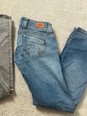 Jeans från Pepe Jeans - Säljer super snygga blå och grå low waist jeans från Pepe Jeans med klassisk femficksmodell och ljus tvätt. Jeansen har en läderpatch med logga bak i midjan och raka ben.💞Säljer dom för 750kr styck, så alltså båda för 1 500kr.