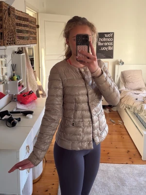 Herno jacka  - Snygg beige pufferjacka med rund halsringning och två framfickor med knappstängning. Jackan har en lätt vadderad look och stängs framtill med tryckknappar. Perfekt för kalla dagar och ger en stilren siluett. Från herno! Såååå fin till våren, använts fåtal gånger men bra skick. 