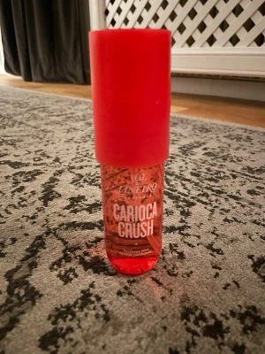 Sol de Janeiro Carioca Crush mist - Fräsch och tropisk body mist från Sol de Janeiro i doften Carioca Crush. Flaskan är cylinderformad i genomskinligt röd plast med vit spraypump och rött lock. Perfekt för dig som gillar söta och fruktiga dofter.