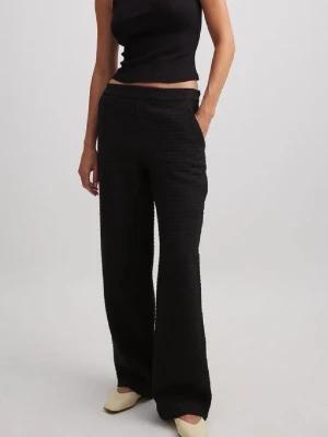 Svarta vida byxor i strukturmaterial - Säljer ett par svarta byxor med vid passform och hög midja. Byxorna har en snygg struktur i materialet och raka ben som ger en chill och trendig look. Perfekta att styla med crop tops eller oversized skjortor.