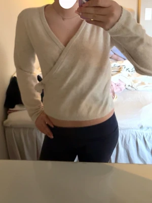 Beige omlottstickad tröja - Snygg beige stickad omlott-tröja med långa ärmar och v-ringning!💕den är köpt från Kappahl och använd fåtal gånger!