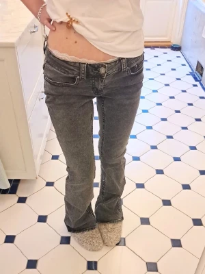 Grå svarta bootcut low waist jeans från gina! - Grå svarta low waist bootcut jeans från gina i storlek 38, vilket motsvarar storlek S💕 köpte förra året men inte använt ofta💕