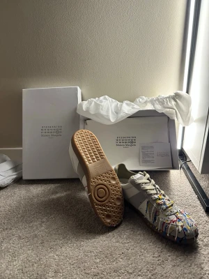 Maison margela  - Maison Margiela sneakers med unik färgstänkdesign. Levereras med originalkartong och dammpåse, visar minimala tecken på slitage. ⭐️ Skick: 9/10 🎨 Färg: Flerfärgad 📦 Snabb och noggrann frakt (kan gö byte emot airpodsmax, flycrews,Gucci ace eller andra maison margela)